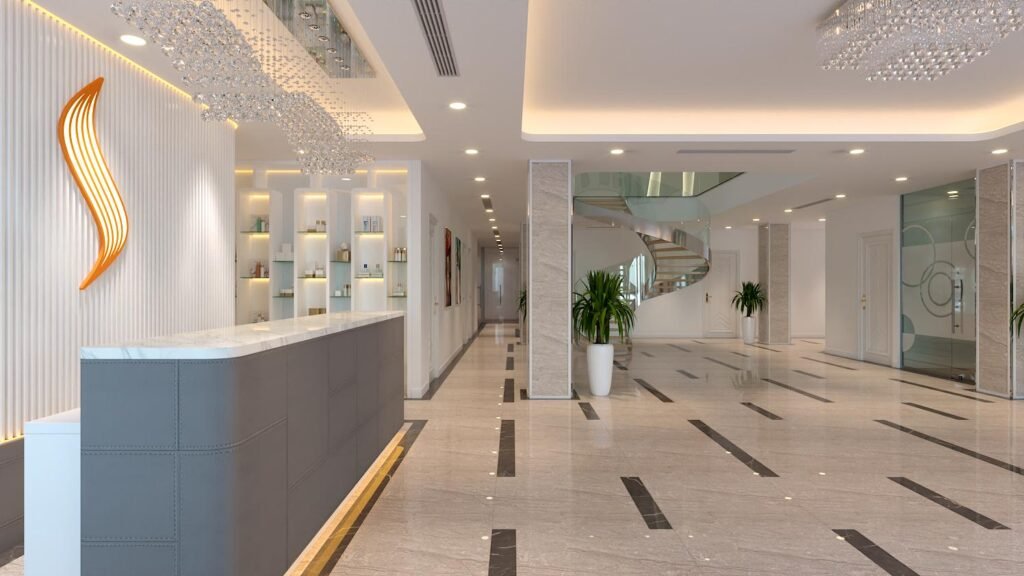 Sảnh lễ tân Saigon Smile Spa Hà Nội với quầy xám, mặt đá sáng và cầu thang xoắn